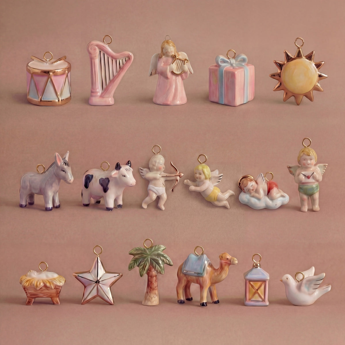 Collection of small ceramic figurines on a pink background