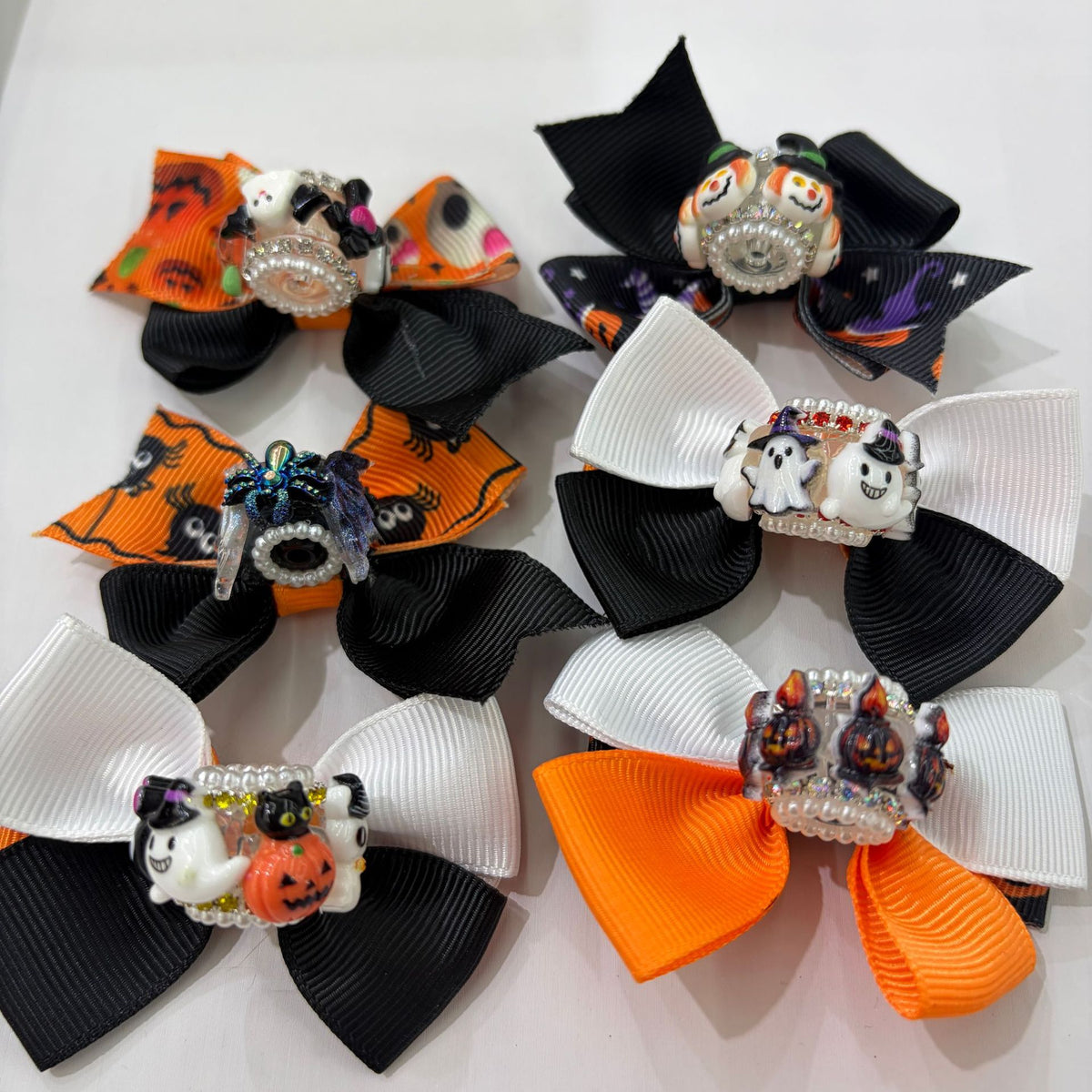 Six Halloween ribbon bow focal beads in black, white, and orange on a white background