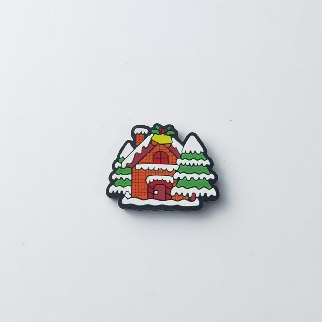Snow-covered orange cabin silicone focal bead with green trees, white snow and yellow bell