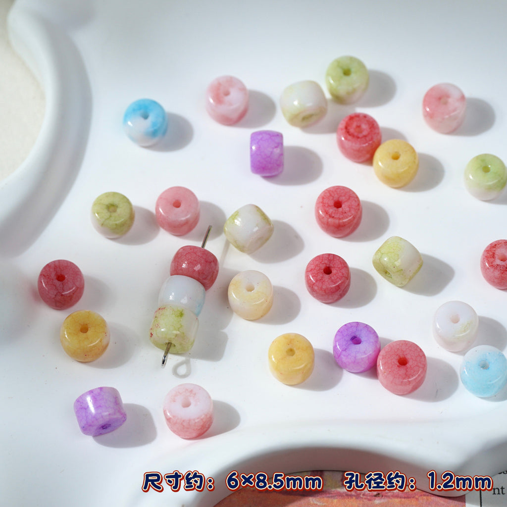 Multicolor round and cylindrical porcelain craft beads on white surface
