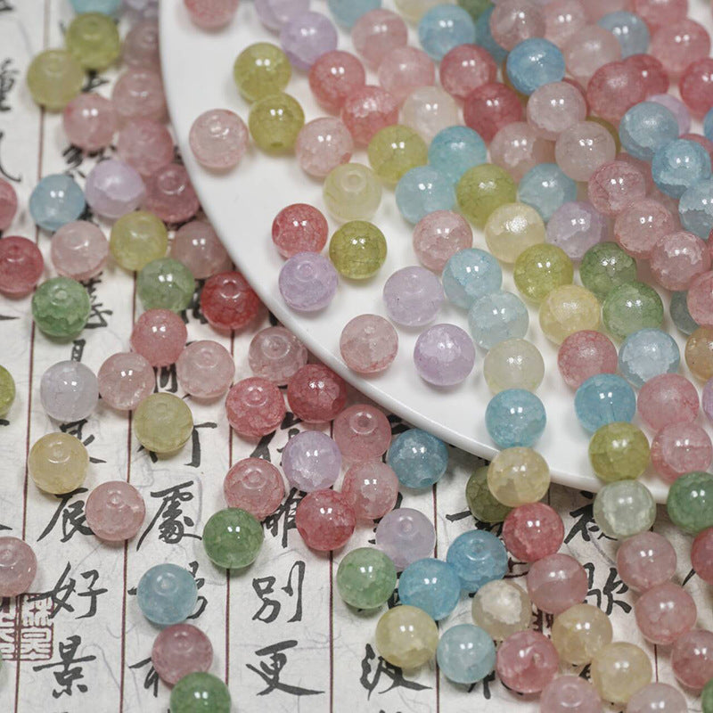Pastel multicolor ice-crackle glass beads spilling from a white plate