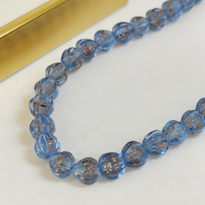 Strand of translucent light blue lantern glass beads with brown inclusions