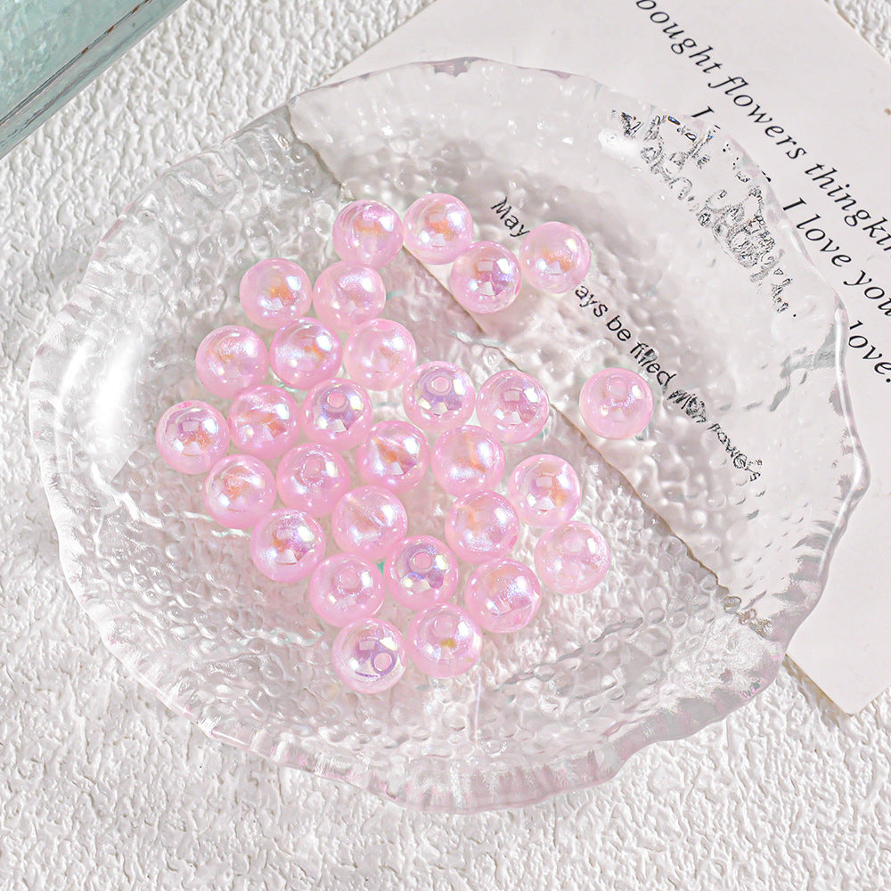 Pile of round glossy pink glass beads with iridescent glitter inside