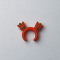 Orange silicone ring featuring two small reindeer heads with antlers, on a plain gray background