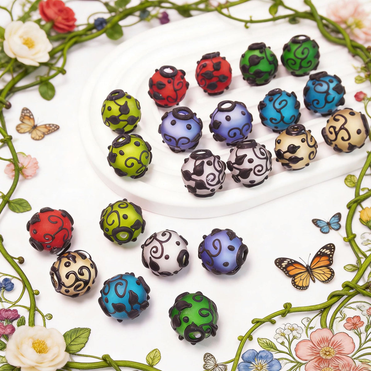 Colorful round frosted glass beads with black swirl patterns on a white plate and floral butterfly background