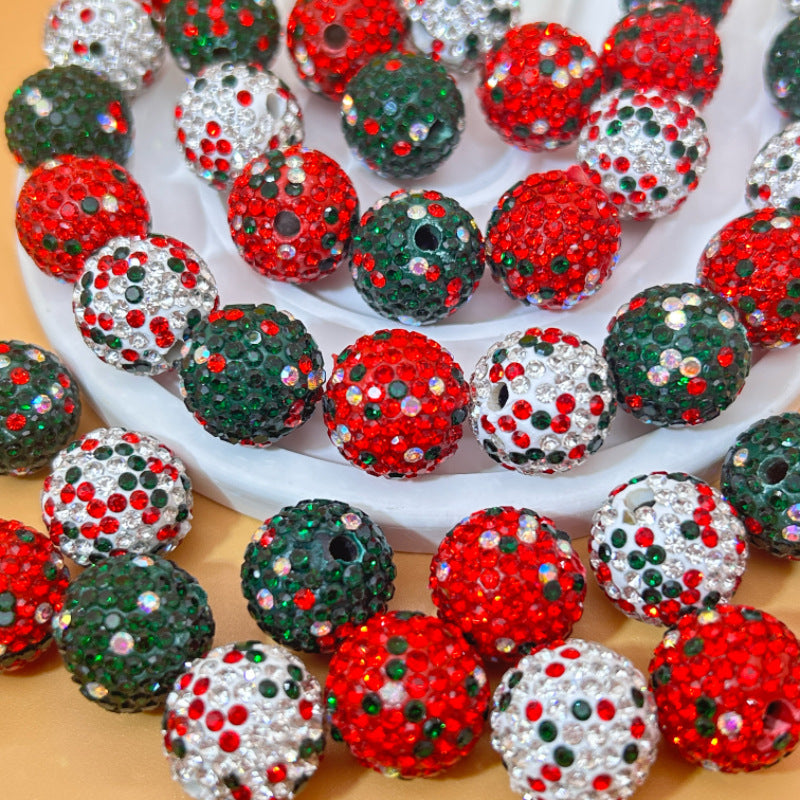 Colorful embellished Christmas beads on a white and gold background.