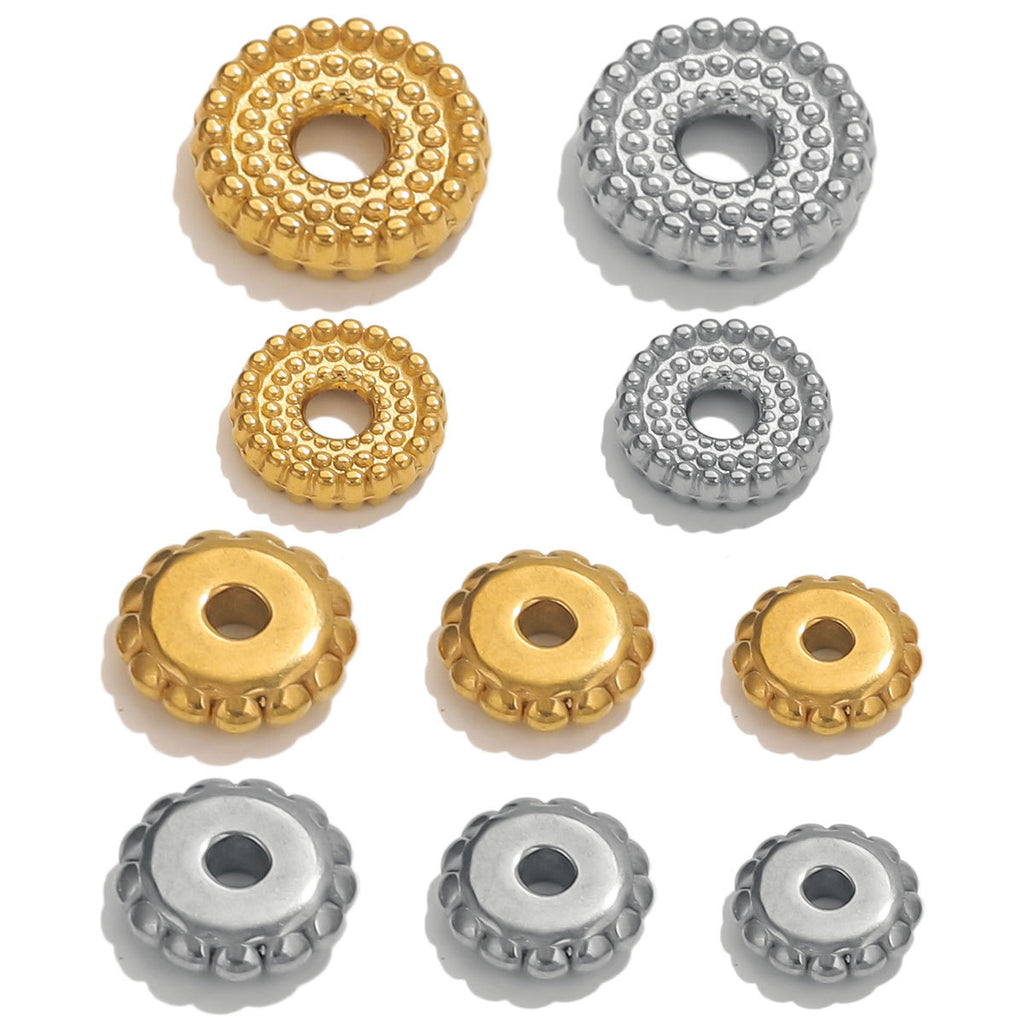 Nine dotted gear wheel stainless steel spacer beads in gold and steel finishes on white background