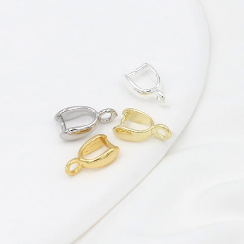 Four small gold-plated pinch bail pendant clasps in gold and silver finishes on a white curved surface
