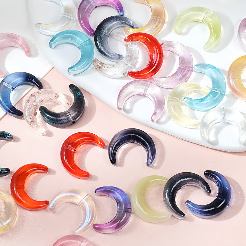 Colorful glazed glass crescent moon beads arranged on a pink and white split background