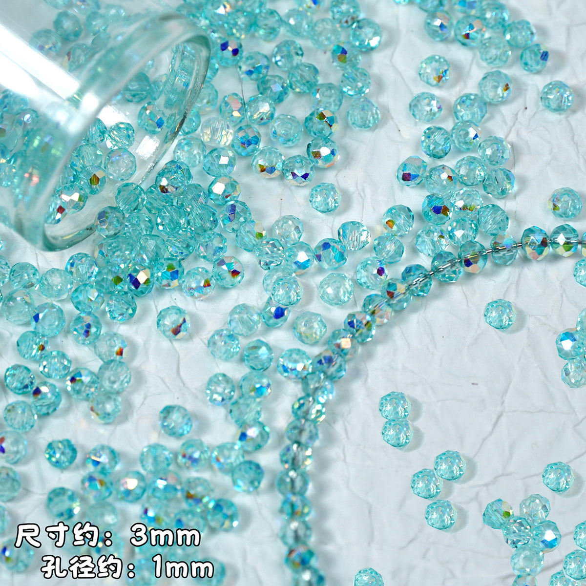 Light blue faceted round beads spilling from a clear glass container on a textured white background, with Chinese text indicating approximate size: 3mm diameter and 1mm hole size.