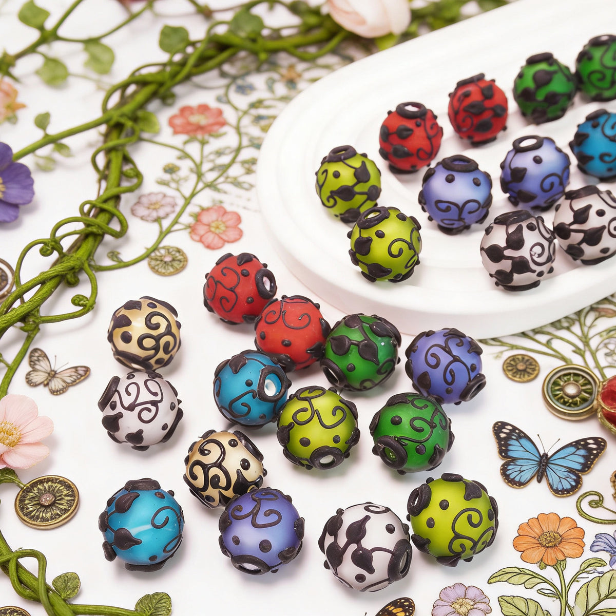 Colorful round frosted glass beads with black swirl patterns on a white plate and floral surface