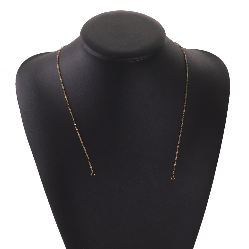 Gold-tone stainless steel chain connector link with ring ends draped on a black mannequin bust