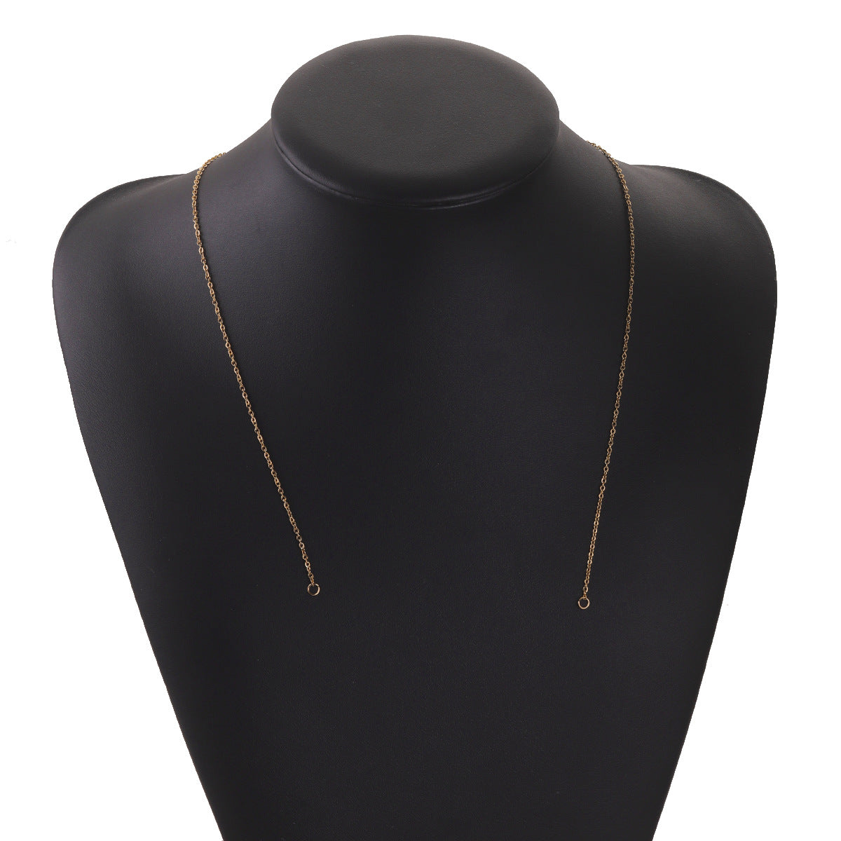 Gold-tone stainless steel chain connector link with ring ends draped on a black mannequin bust