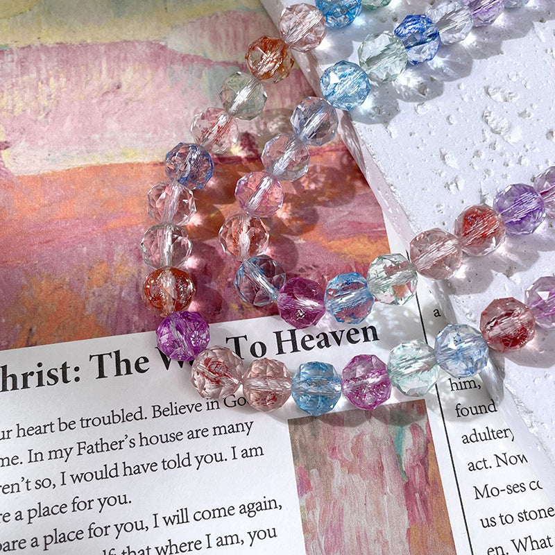 Strand of faceted glass beads in assorted pastel colors on an open book with printed text