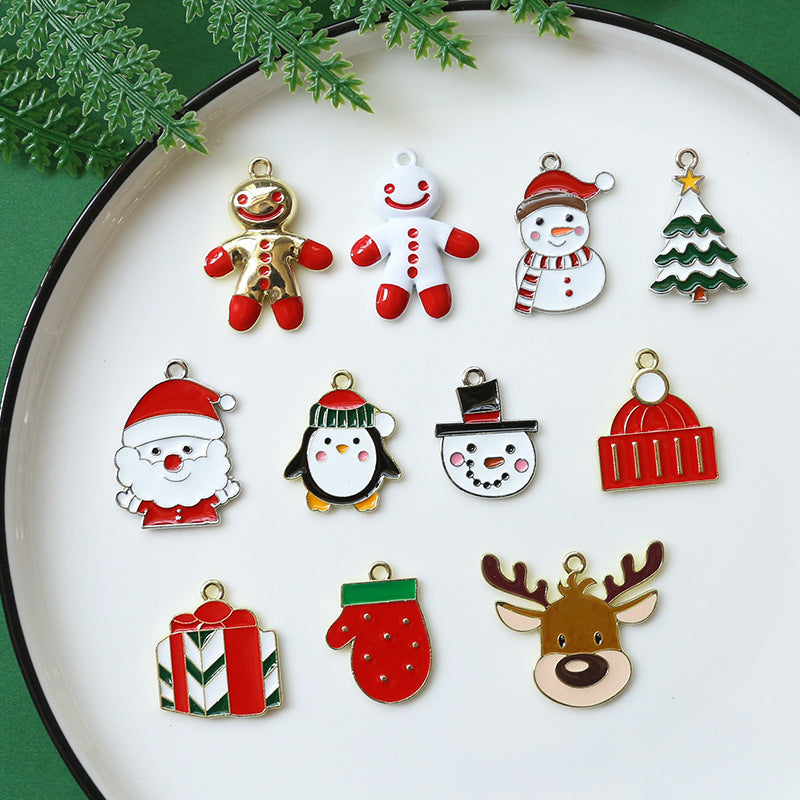 Set of 12 Christmas-themed enamel alloy charms on a white plate with black rim