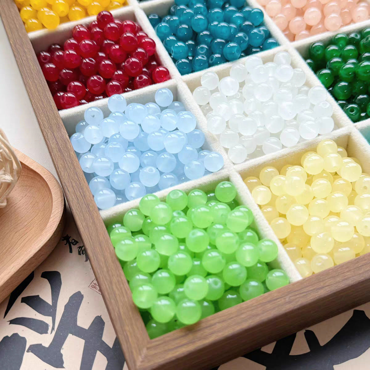 Colorful imitation jade round beads in a wooden compartment box