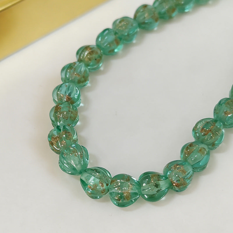 Close-up of translucent green lantern glass beads with gold leaf inclusions