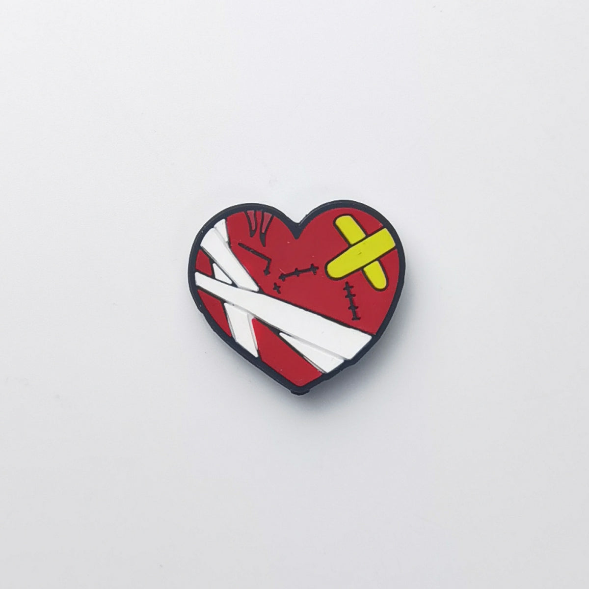 Heart-shaped bead with red heart, bandages and yellow band-aid