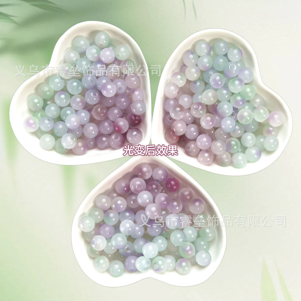 Three heart-shaped bowls of iridescent pastel lavender, mint, and pale blue beads