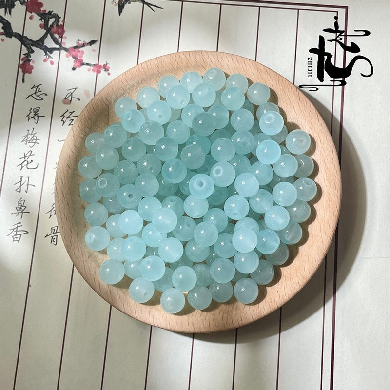 Light blue round beads in a wooden bowl on white background with black text