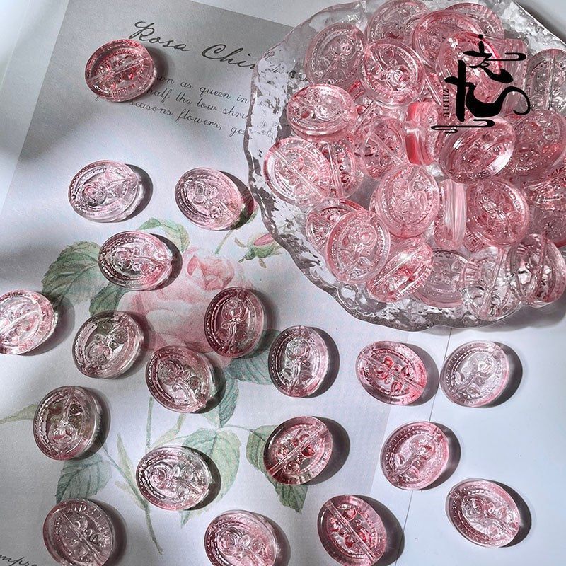 Pink translucent oval engraved glass rose beads on white floral paper