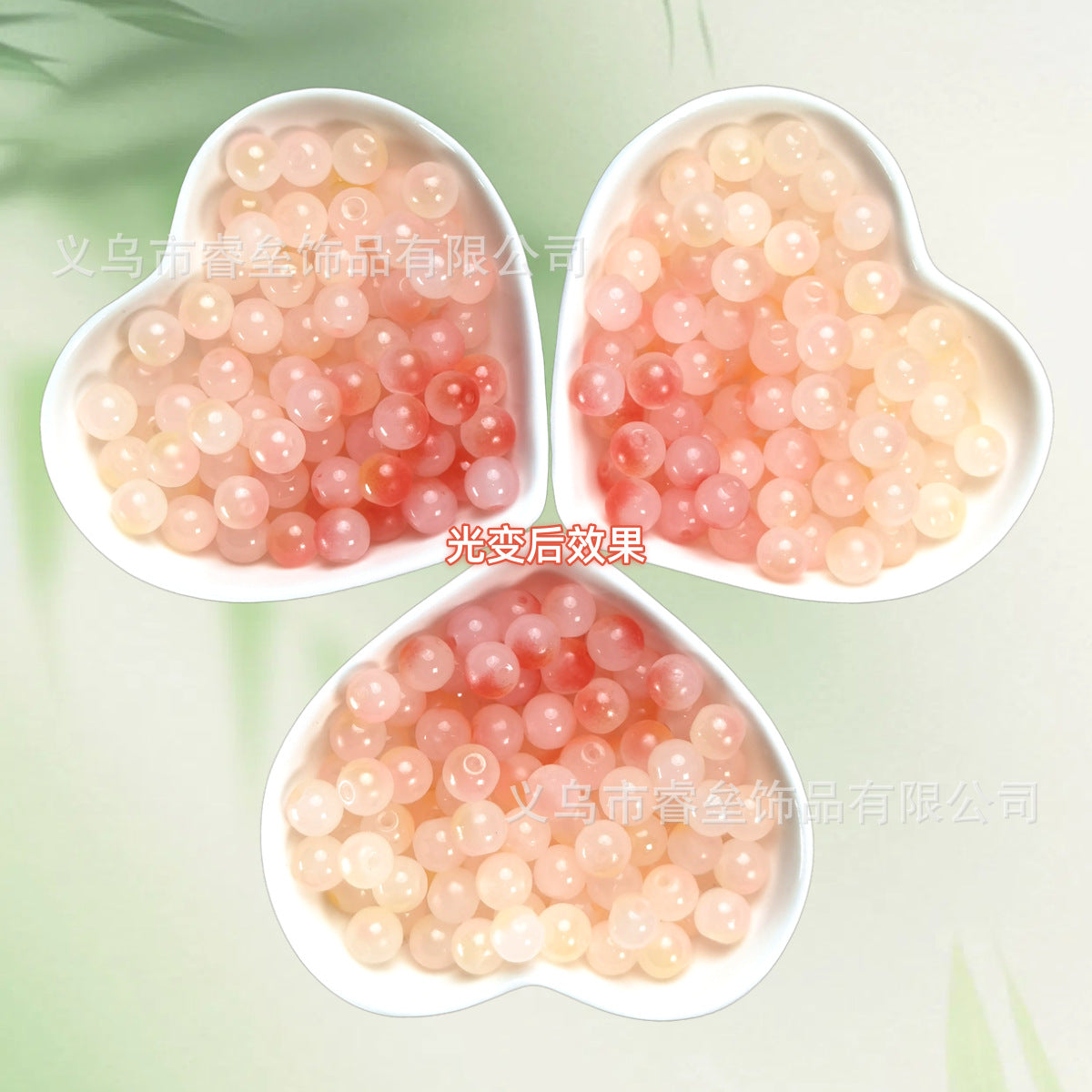 Three heart-shaped dishes of translucent peach and pink beads on pale green