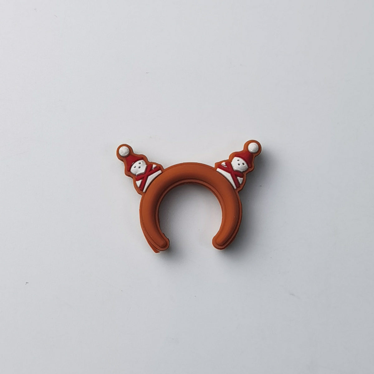 Terracotta orange-brown silicone U-shaped ring decorated with two small snowmen, on a plain background