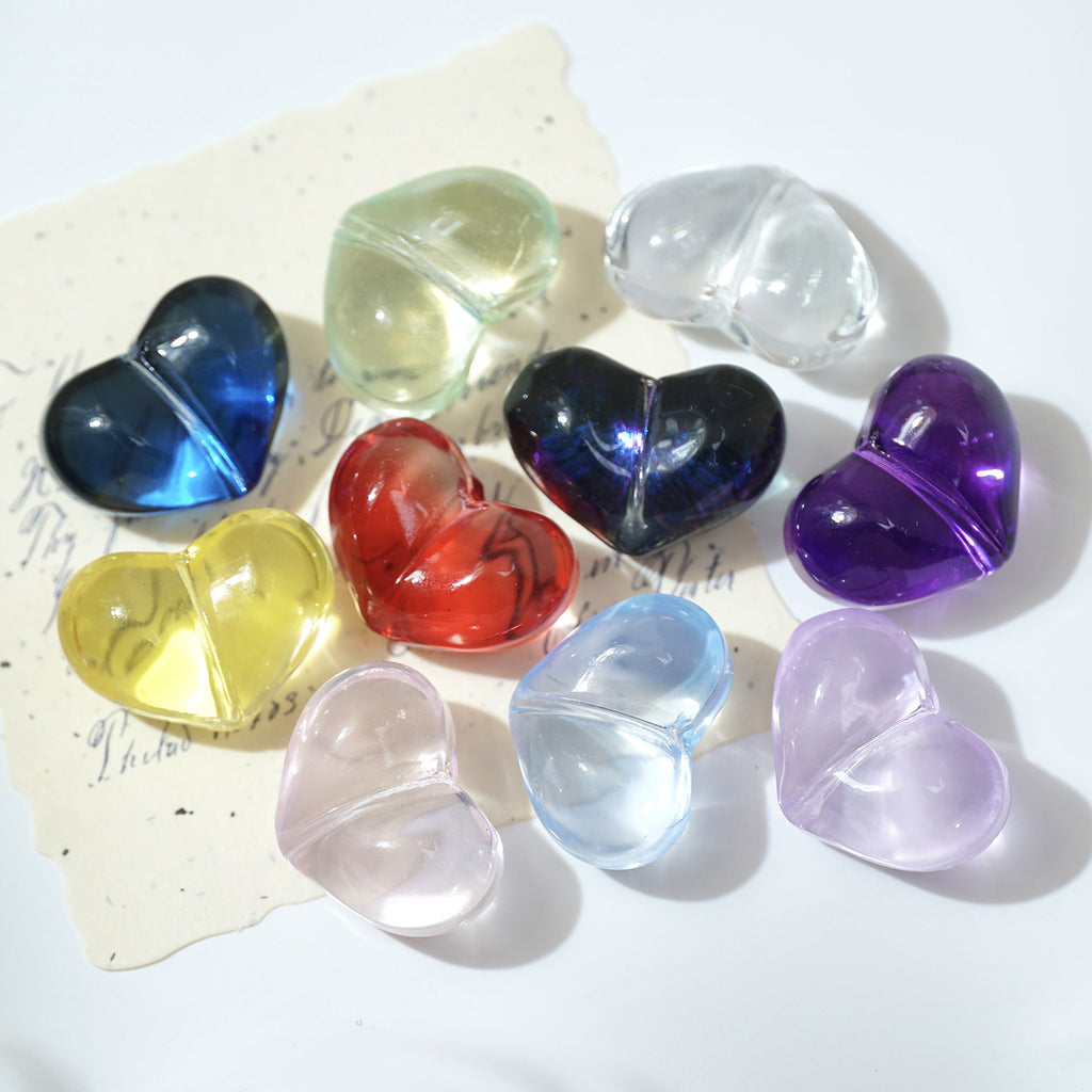 Nine translucent heart-shaped crystal-glass beads in blue, green, red, purple, pink, and clear