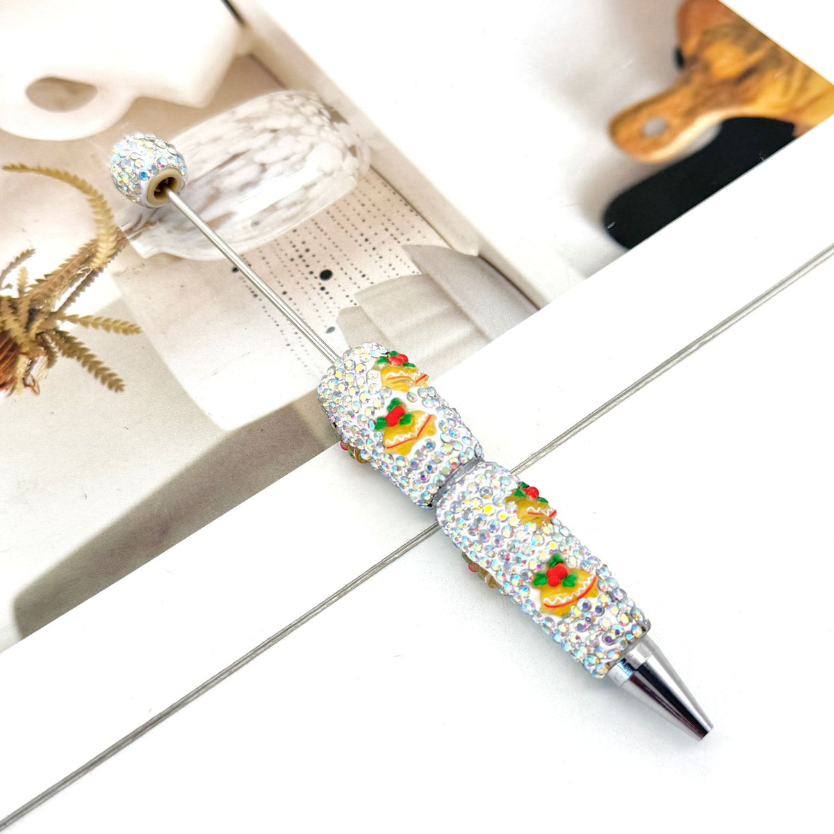 Silver metal ballpoint pen heavily embellished with rhinestones.