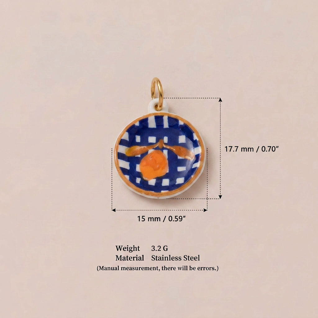 Round pendant charm with blue checkered pattern and orange fruit, shown with size measurements.