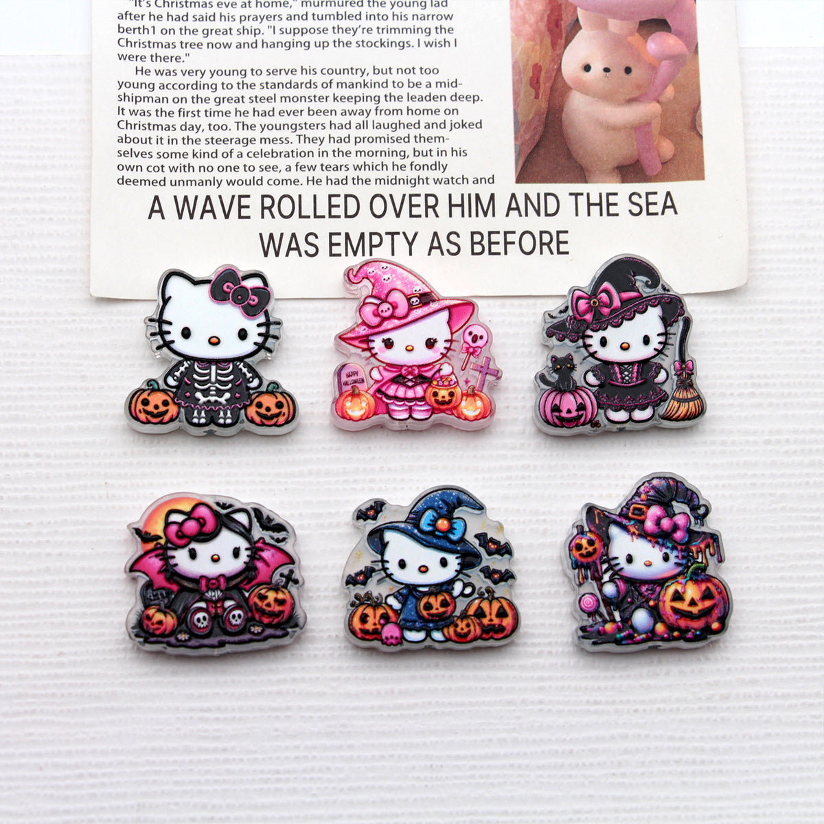 Six Hello Kitty Halloween acrylic charms in skeleton, wizard, witch, vampire costumes on white surface