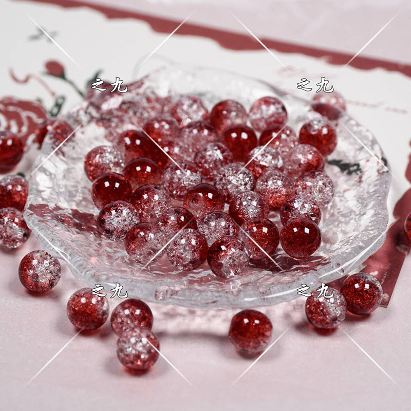 Red glittery round beads with frosted coating on a clear glass plate