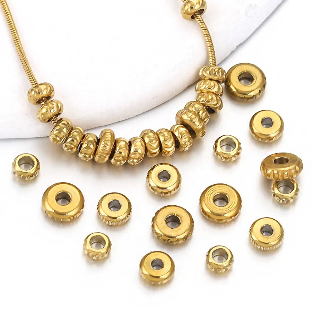 Close-up of gold-plated diamond-cut stainless steel abacus spacer beads with textured edges