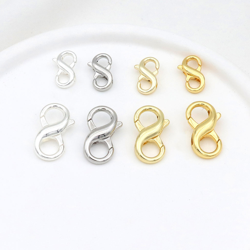 Eight figure-eight lobster clasps in two sizes and silver and gold finishes arranged in two rows on white
