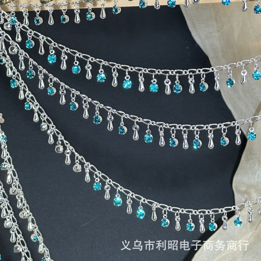 Silver chains with dangling turquoise blue rhinestones and teardrop charms on black fabric