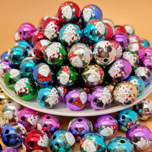 Colorful shiny Santa Claus printed acrylic round beads piled on a white plate with some scattered around