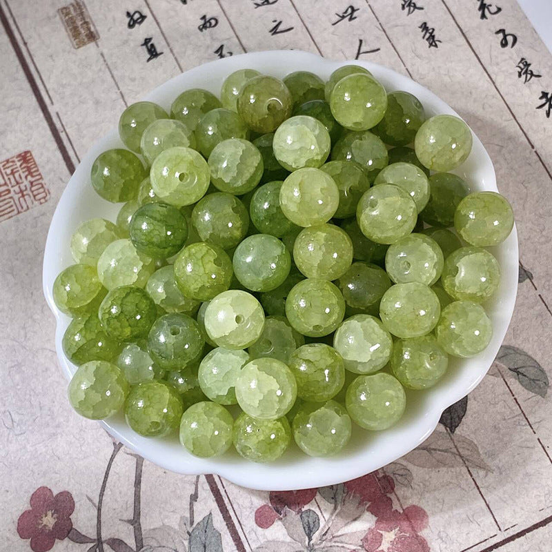 Green 10mm water-dyed jade-style crackle glass beads in a white bowl