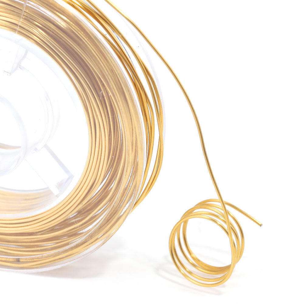 Close-up of a spool of gold wire with a small coil extending right, white background.