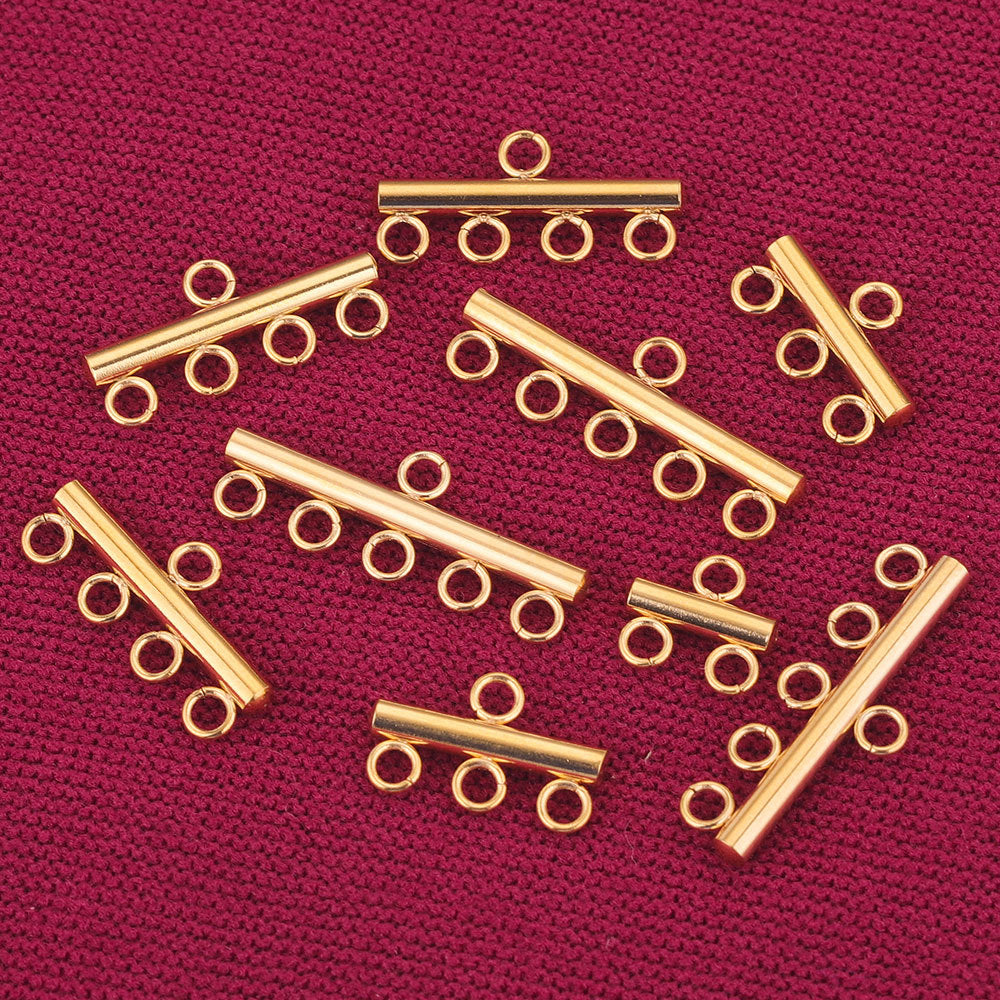 Gold-toned stainless steel multi-loop connector bars arranged on dark red textured fabric