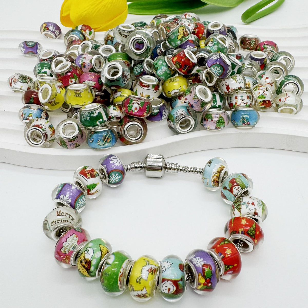 Colorful Christmas-themed acrylic beads with silver spacers in a loose pile