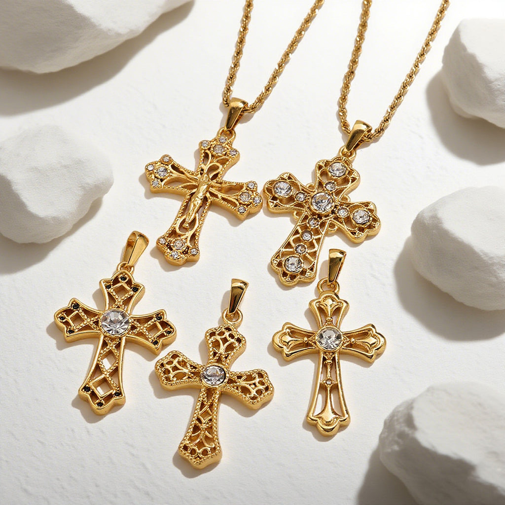 Five gold cross pendant necklaces with clear rhinestone accents on a white textured surface