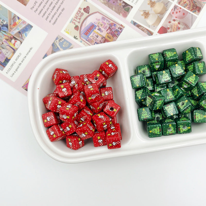 Red square beads with Santa faces and green square beads with Christmas tree prints in a divided tray
