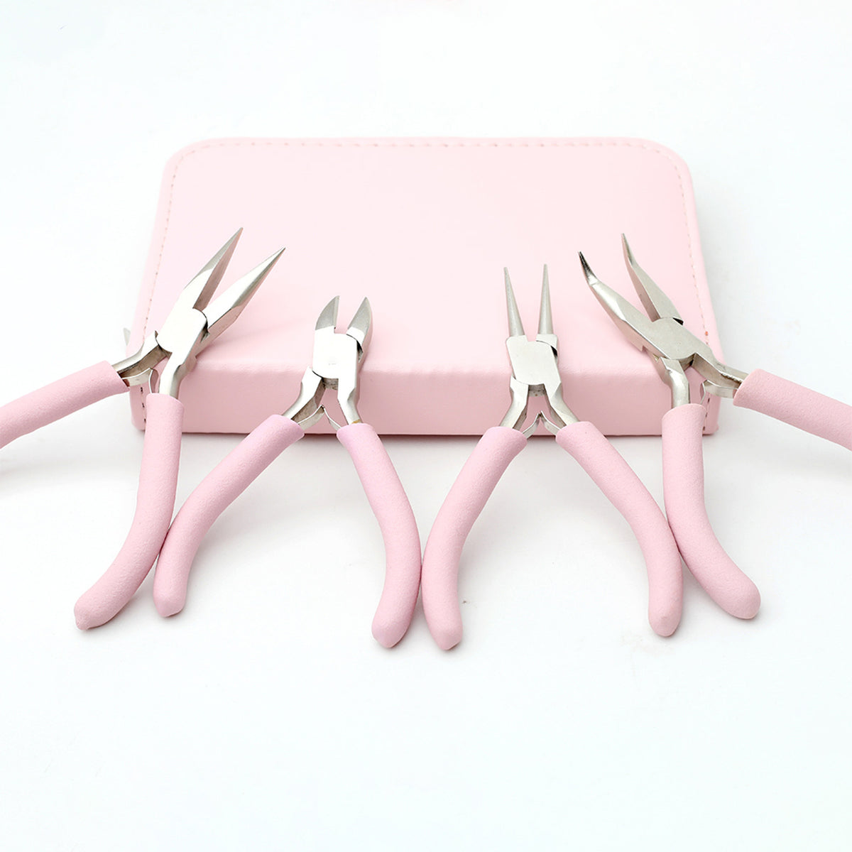 Five pink-handled wire cutters in front of a small pink case