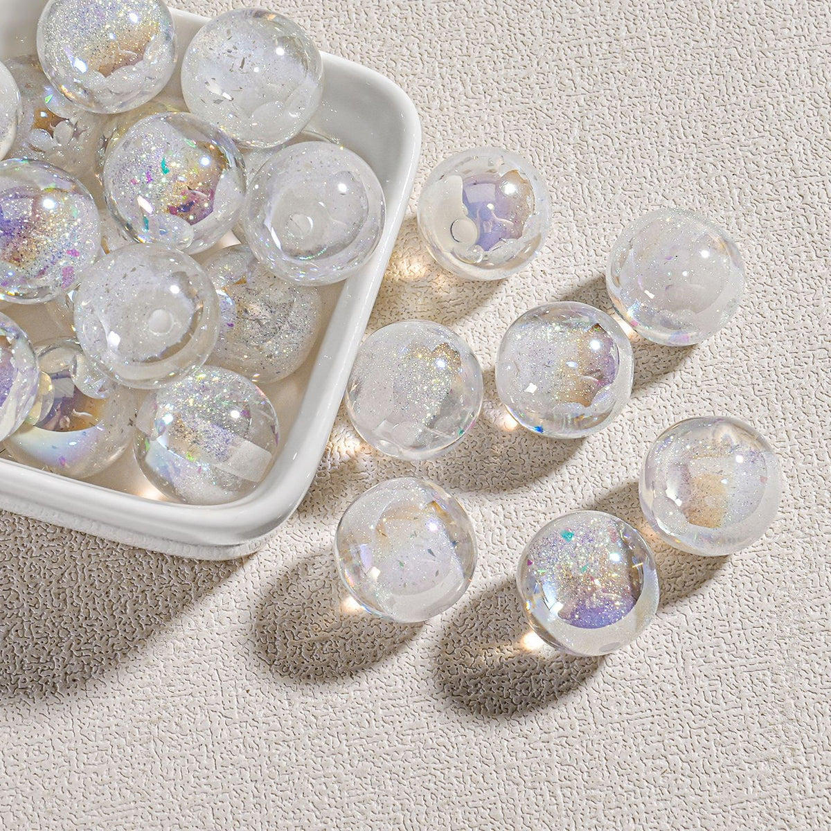 Clear round candy-core opal-effect resin beads filled with white glitter and iridescent flecks