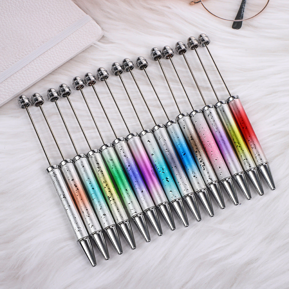 Twelve ombre beadable ballpoint pens with colorful gradient handles in a fan shape.