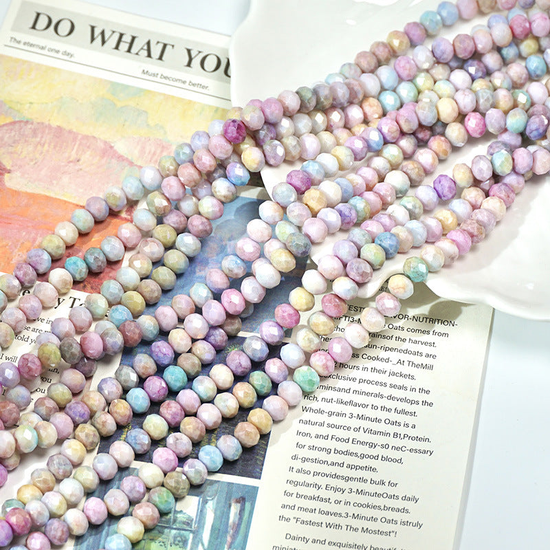 Close-up of pastel marbled round beads on an open book with a heart pendant