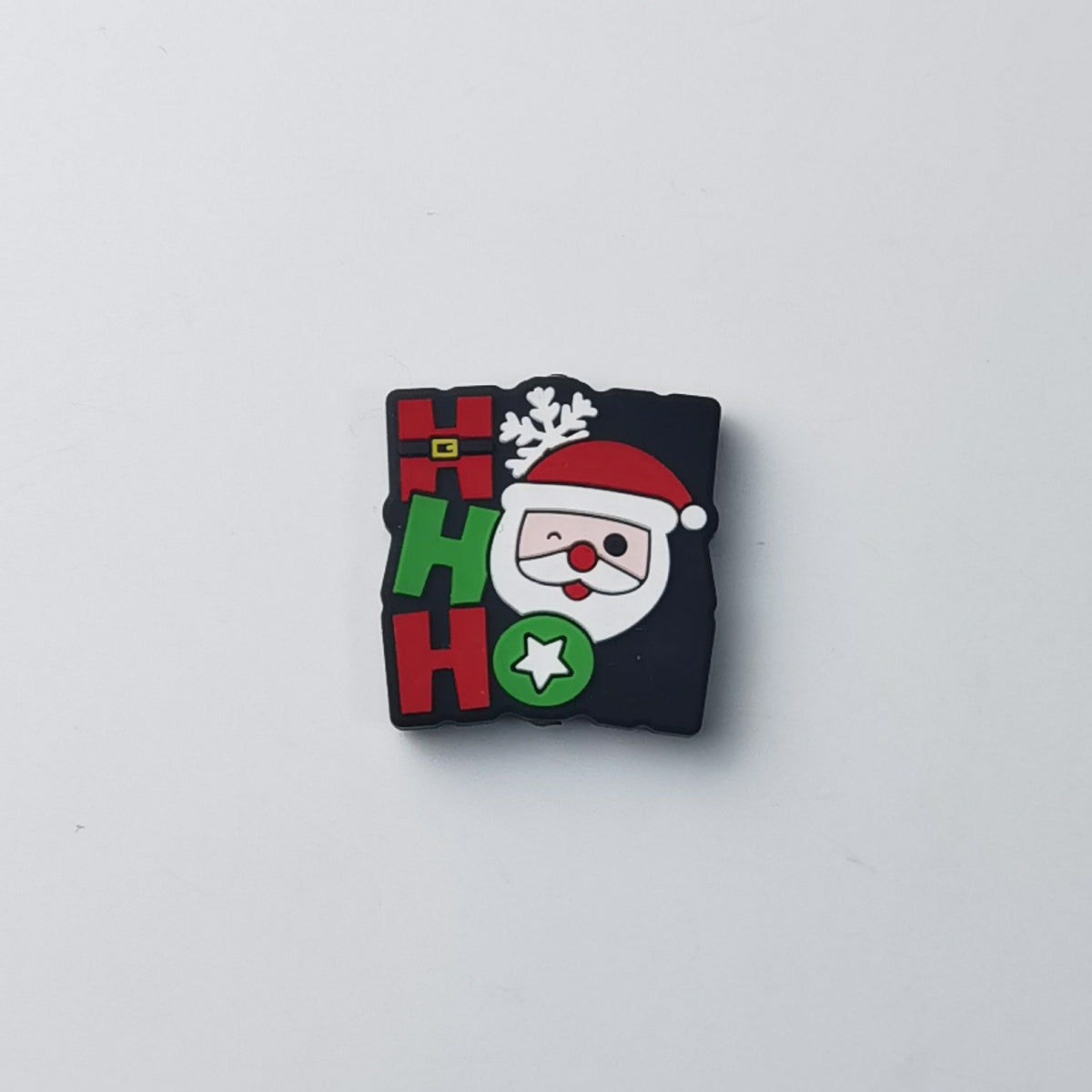 Square black silicone focal bead with red and green 'HO HO' lettering, Santa Claus face, snowflake and star