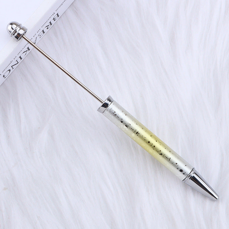 Metallic ombre beadable pen with textured grip on a white fabric background.