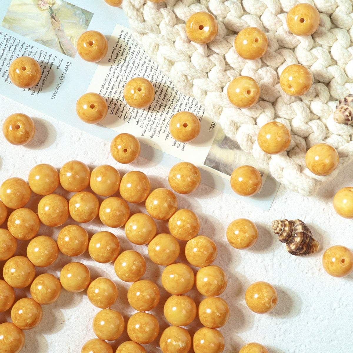 Amber-yellow marbled round glass beads with drilled holes on a white surface