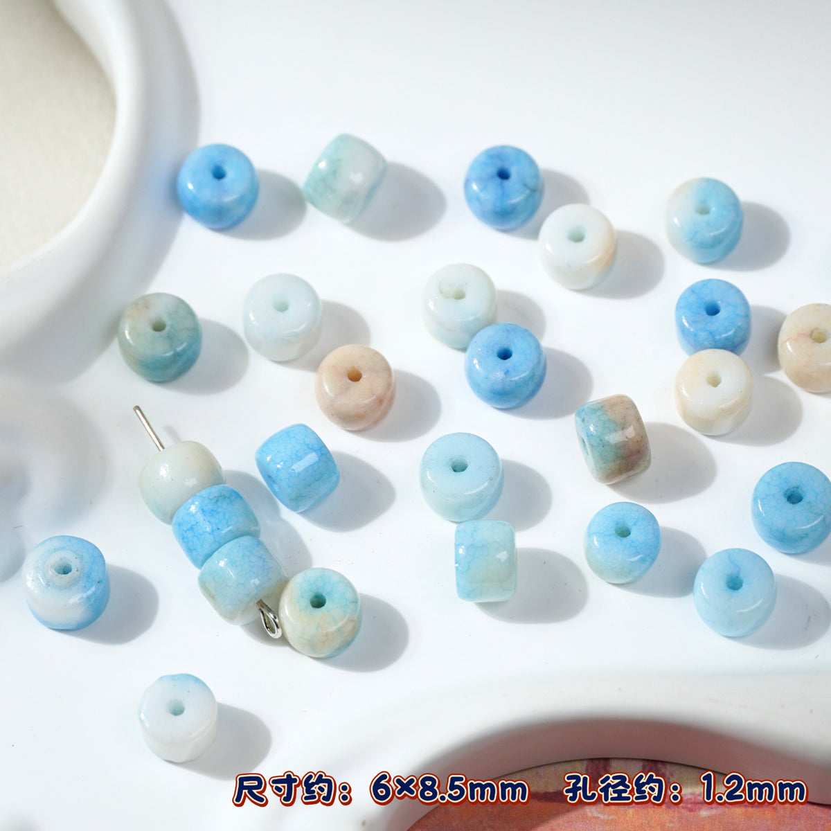 Blue and white marbled round porcelain seed beads on white, silver bead chain
